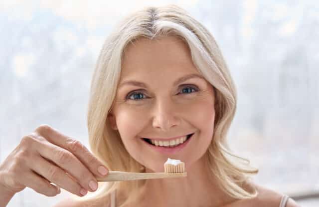 An experienced dentist in Istanbul gently examining an elderly patient's gums during a routine check-up, focusing on gum health and aging concerns.